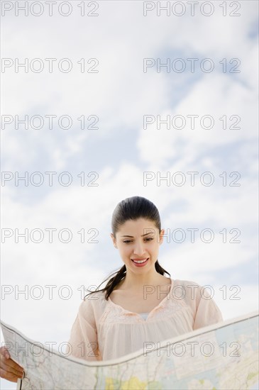 Mixed race woman looking at map