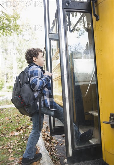 Mixed race boy getting onto school bus