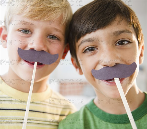 Boys playing with costume mustaches