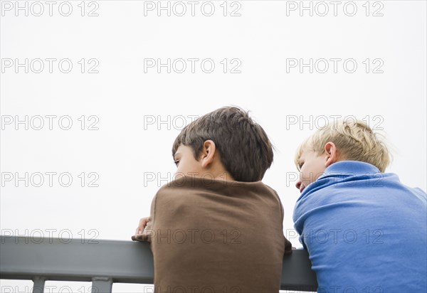 Boys standing looking over railing