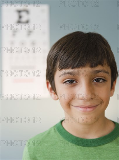 Smiling Hispanic boy having eye test