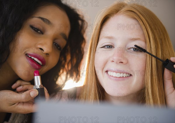 Smiling woman putting on makeup