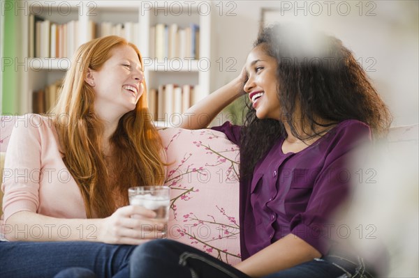 Friends sitting on sofa talking