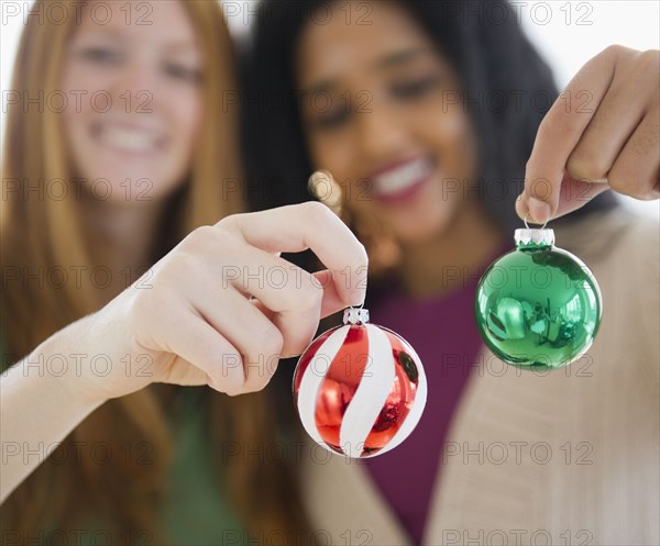 Friends holding small Christmas ornaments
