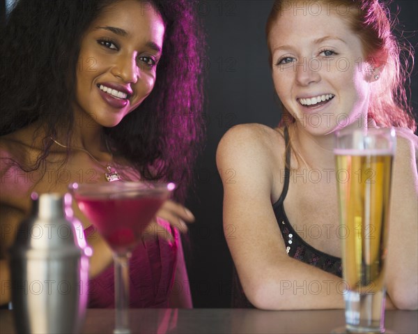 Smiling friends drinking cocktails