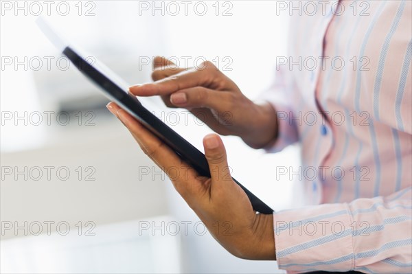 Hispanic businesswoman using digital tablet in office