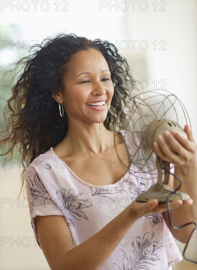 Hispanic woman holding old-fashioned fan