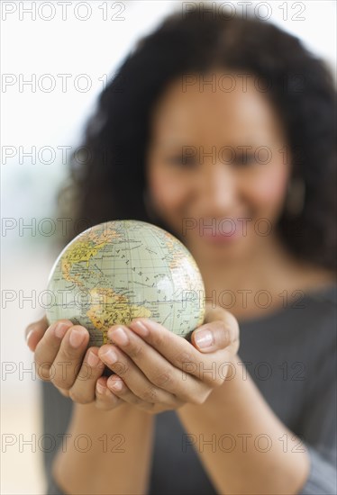 Hispanic woman holding small globe