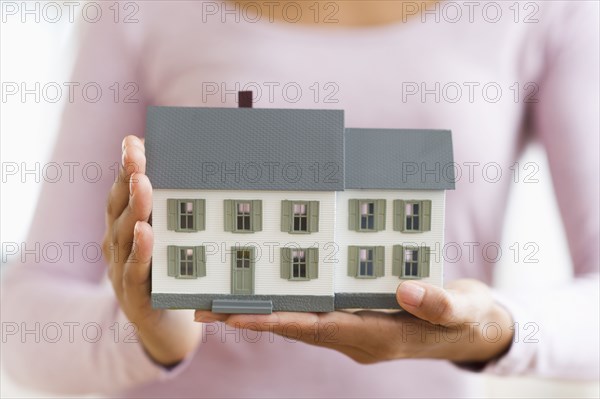 Hispanic woman holding miniature house