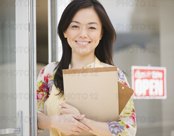 Smiling Japanese woman holding notepad