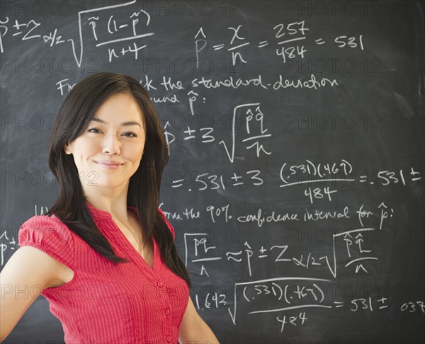 Japanese teacher standing near blackboard