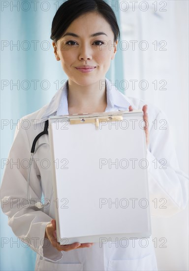 Smiling Japanese doctor holding medical record