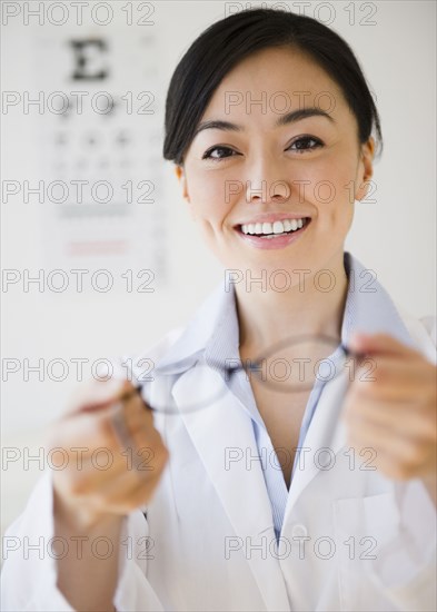 Japanese optometrist holding eyeglasses