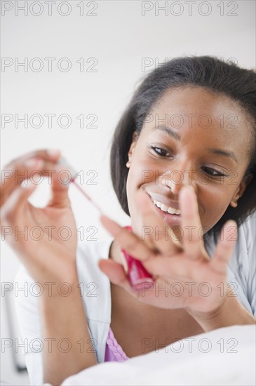 Black woman painting her fingernails