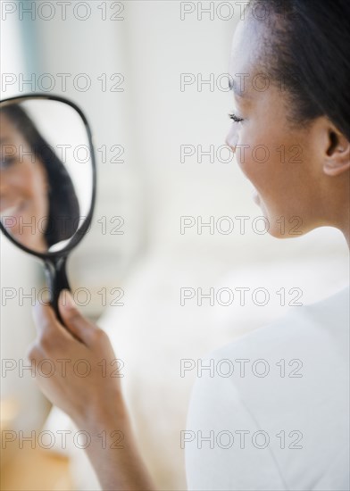 Black woman looking in mirror