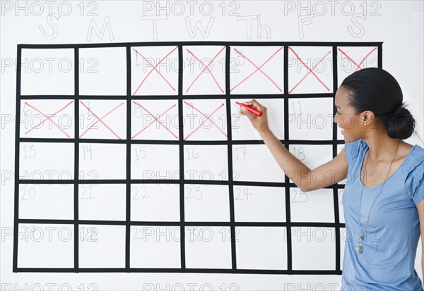 Black woman marking the days off calendar