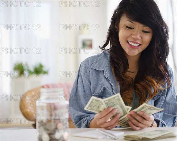 Pacific Islander woman counting money