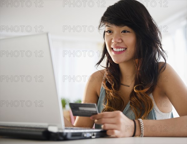 Pacific Islander woman shopping online with credit card