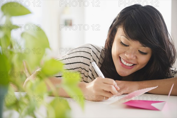 Pacific Islander woman writing on greeting card