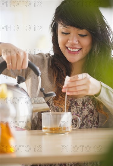 Pacific Islander woman making hot tea