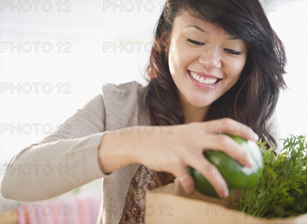 Pacific Islander woman taking groceries from grocery bag