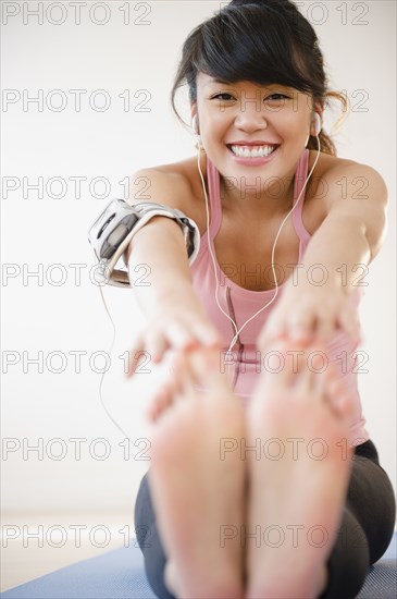 Pacific Islander woman stretching before exercise