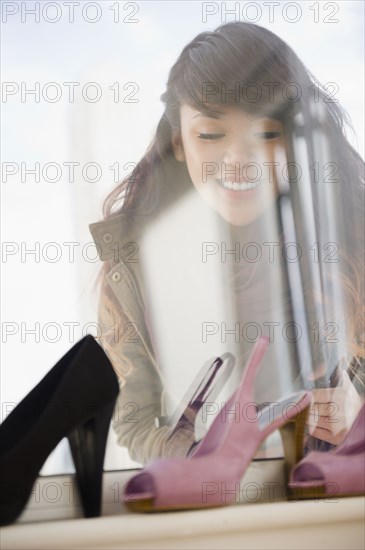 Pacific Islander woman looking at high heels in store