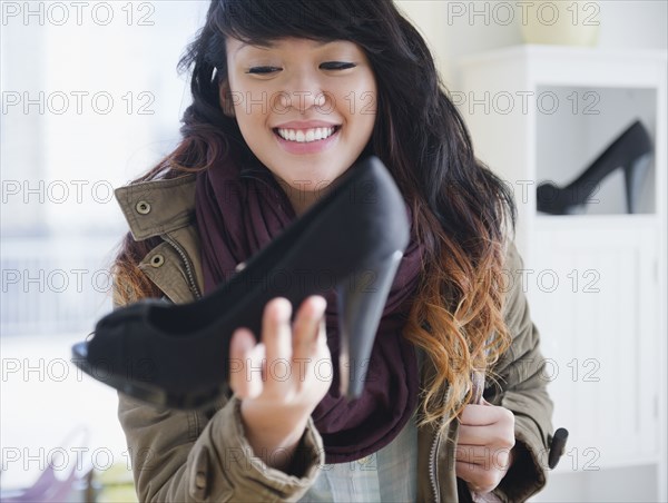 Pacific Islander woman looking at high heels in store