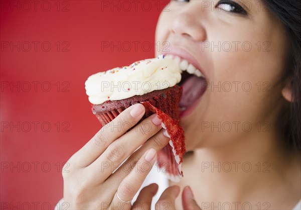 Pacific Islander woman eating cupcake