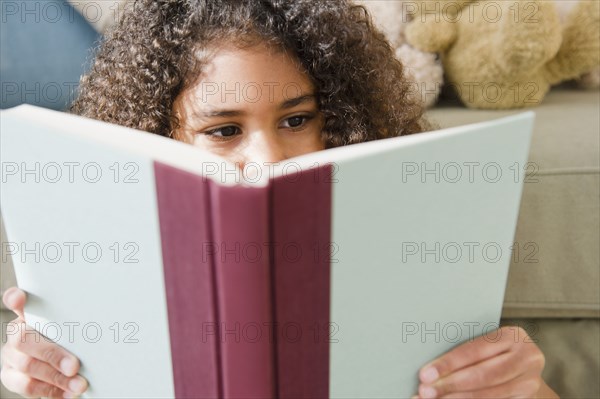 Mixed race girl reading book