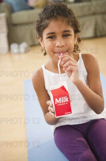 Mixed race girl drinking milk