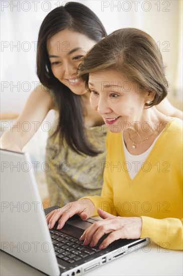 Japanese mother and daughter using laptop together