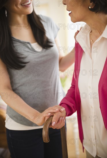 Japanese daughter helping mother walking with cane