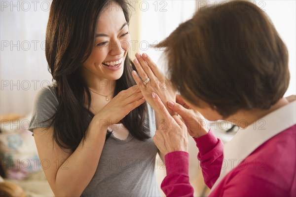 Japanese daughter showing engagement ring to mother