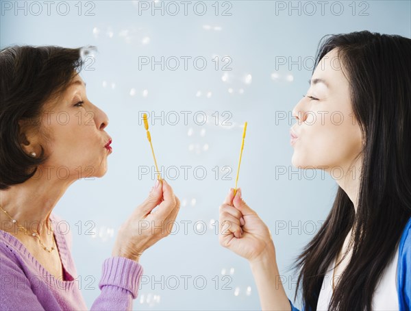 Japanese mother and daughter blowing bubbles