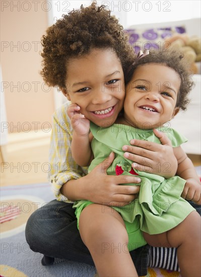 Black brother holding sister on his lap