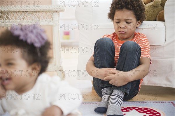 Sad Black boy sitting in living room