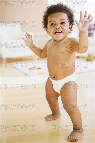 Black baby girl learning to walk