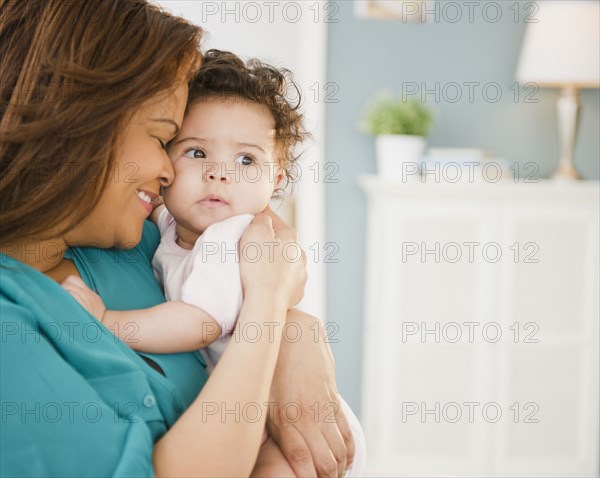 Mixed race mother snuggling baby