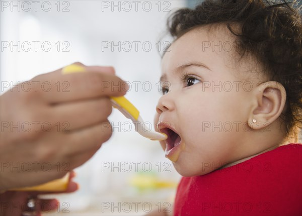 Mixed race mother feeding baby