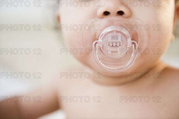 Mixed race baby sucking pacifier