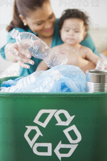 Mixed race mother and baby recycling