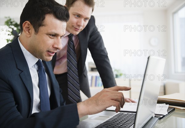 Businessmen working together on laptop