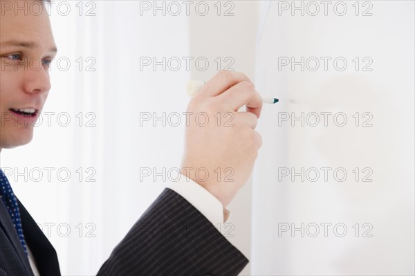 Caucasian businessman writing on whiteboard