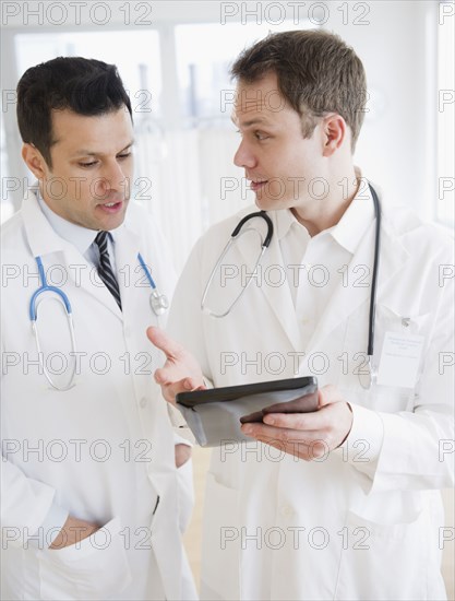 Doctors using digital tablet together