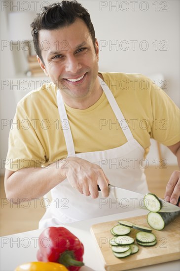 Mixed race man slicing vegetables