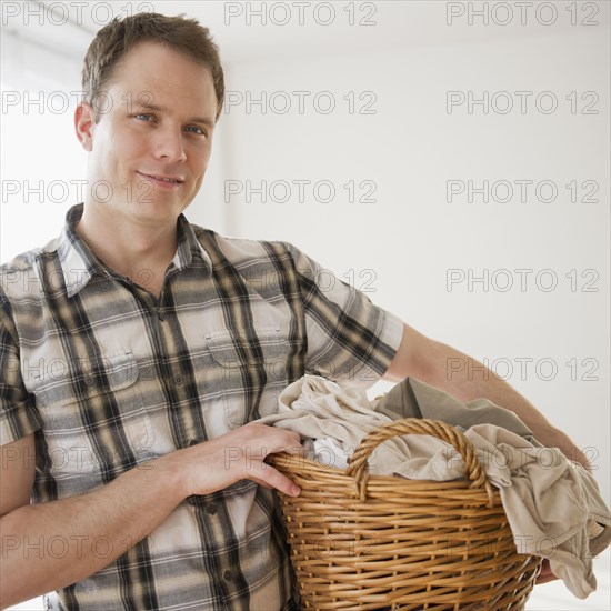 Caucasian man holding laundry basket