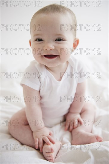 Caucasian baby girl sitting on floor