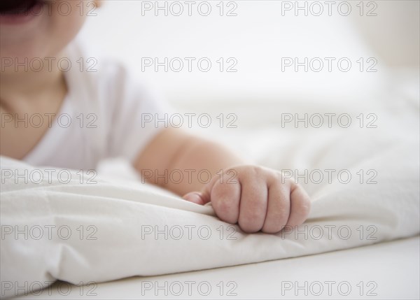 Mixed race baby boy laying on floor