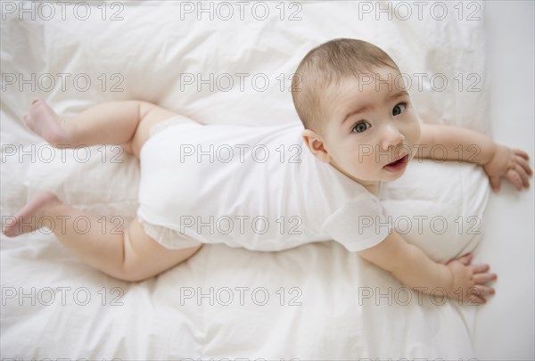 Mixed race baby boy laying on floor